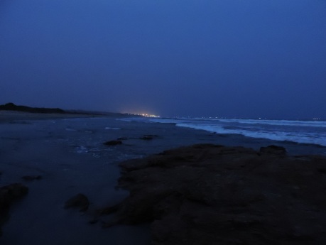 The Port of Tema glows in the distance, lights of ships shine in the dark as our nocturnal archaeoology draws to a close
